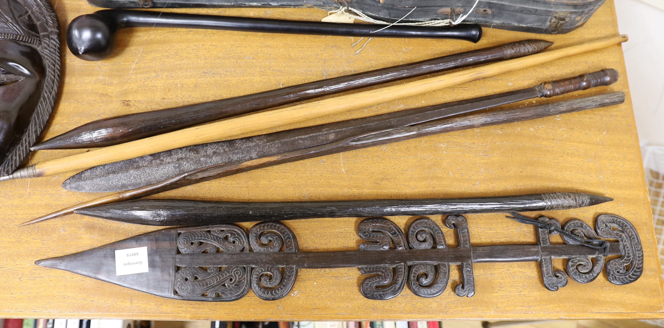 A selection of clubs and weapons to include a knobkerry, together with tribal masks